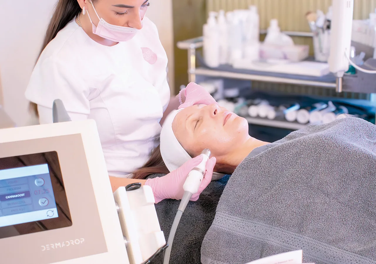 Kosmetikerin mit Maske und Handschuhen bei einer Dermadrop-Behandlung