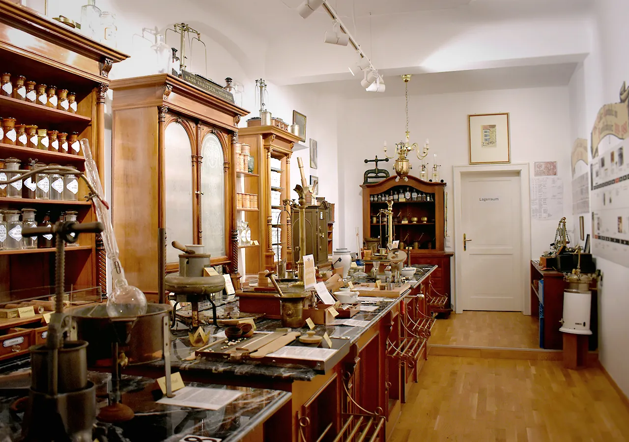 Hauptraum des Adler Apotheken Museums mit historischen Holzregalen, Gefäßen und pharmazeutischen Utensilien
