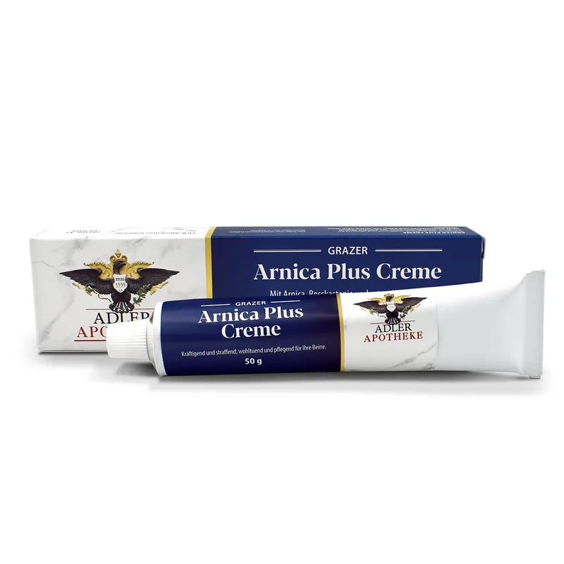 Eine weiße Schachtel mit violettem Etikett der Grazer Arnica Plus Creme. Eine Tube liegt in der Schachtel.