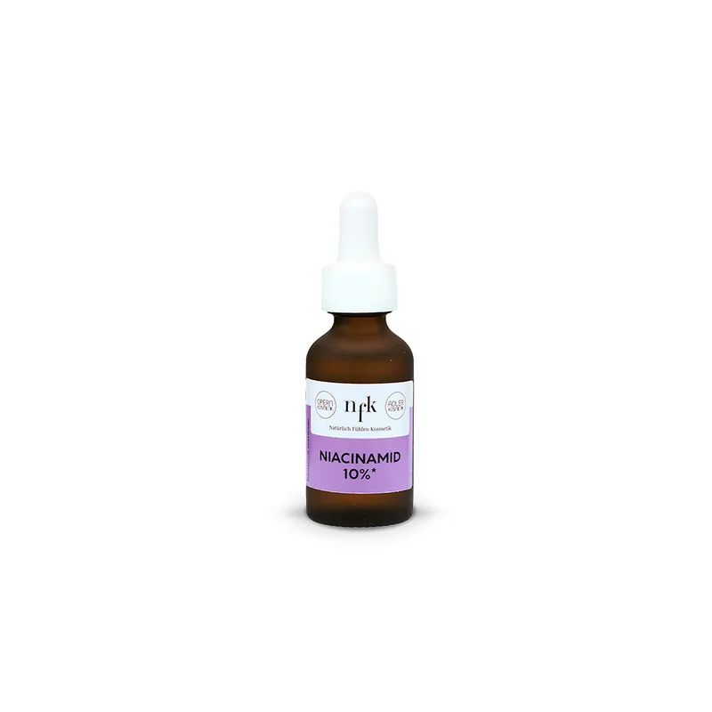 NFK Niacinamid 10% Konzentrat als Serum in einer braunen Glasflasche (20 ml), mit Tropferpipette und Etikett in weißer und lila Farbe, vor weißem Hintergrund.