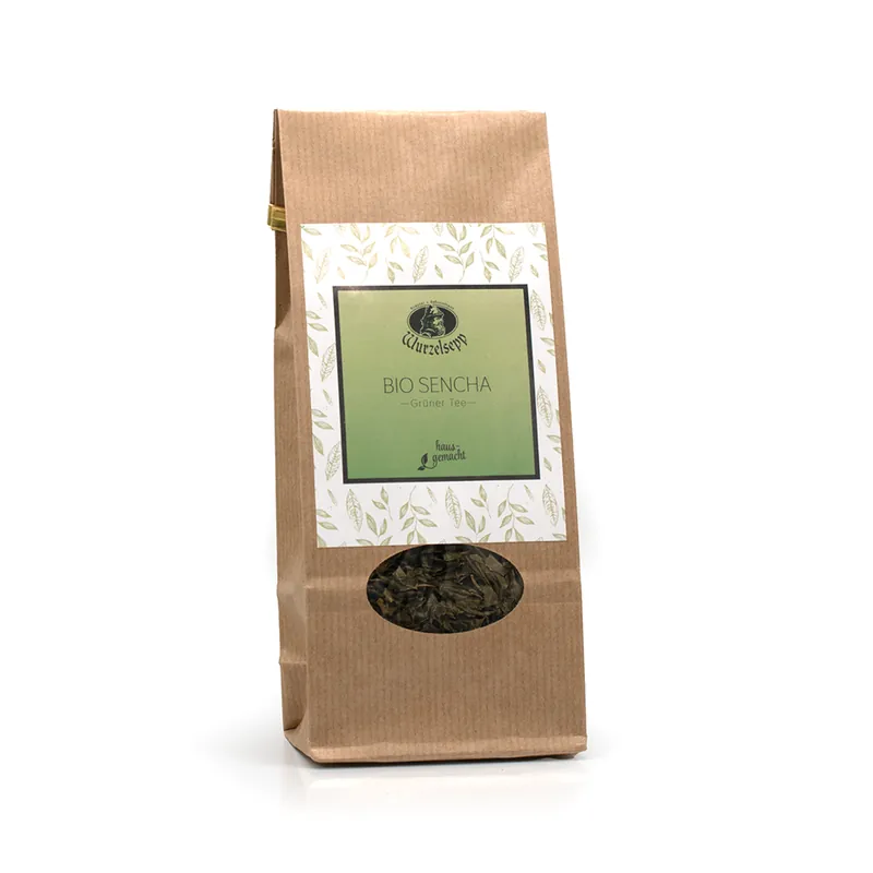 Ein Sackerl in hellbraun mit kleinem ovalen Sichtfenster und weißem Etikett, innen grün. Wurzelsepp Bio Sencha Tee.