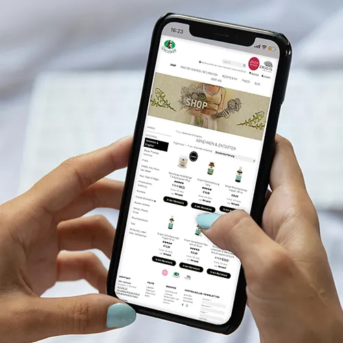 Smartphone mit dem Online-Shop der Adler Apotheke und des Wurzelsepp