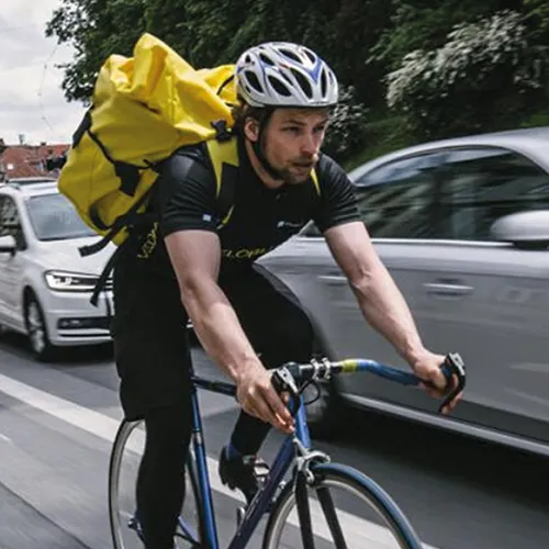 Radbote mit gelbem Rucksack in der Grazer Innenstadt